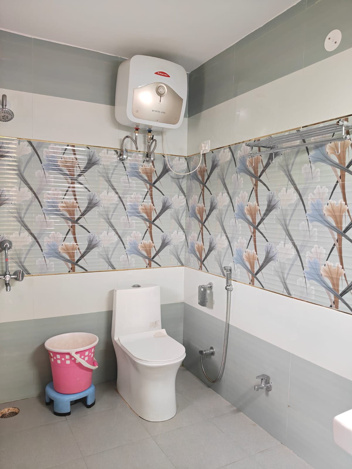 Clean attached bathroom with geyser